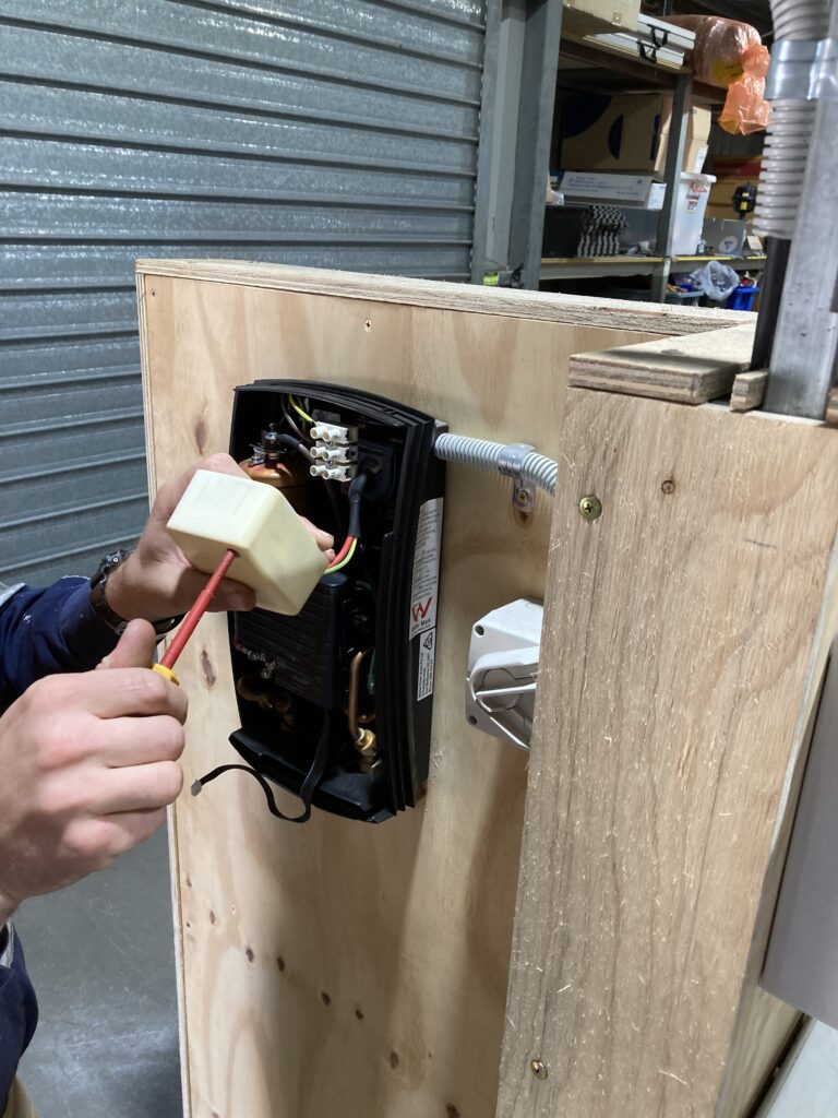 Man working on electrical socket | Featured image for Electronic Equipment – Restricted Electrical Licence Course by Get Skilled Training.