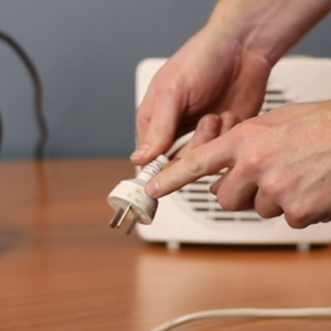 Photo of an electrical plug being visually inspected | Featured image for Test and Tag Training Course page for Get Skilled Training.