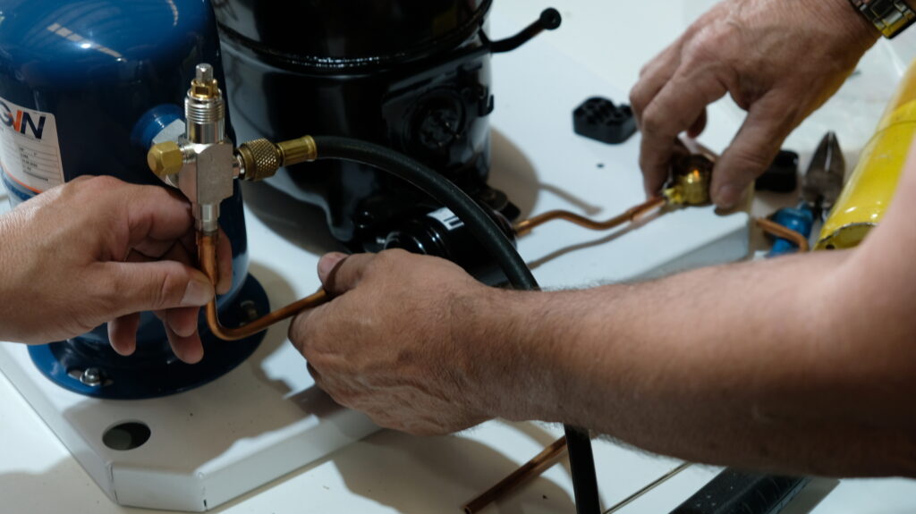 Close up of men working on gas fittings | Featured image for Certificate III in Refrigeration and Air Conditioning on Get Skilled Training.