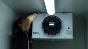 Man installing refrigeration unit | Featured image for Certificate III in Refrigeration and Air Conditioning on Get Skilled Training.