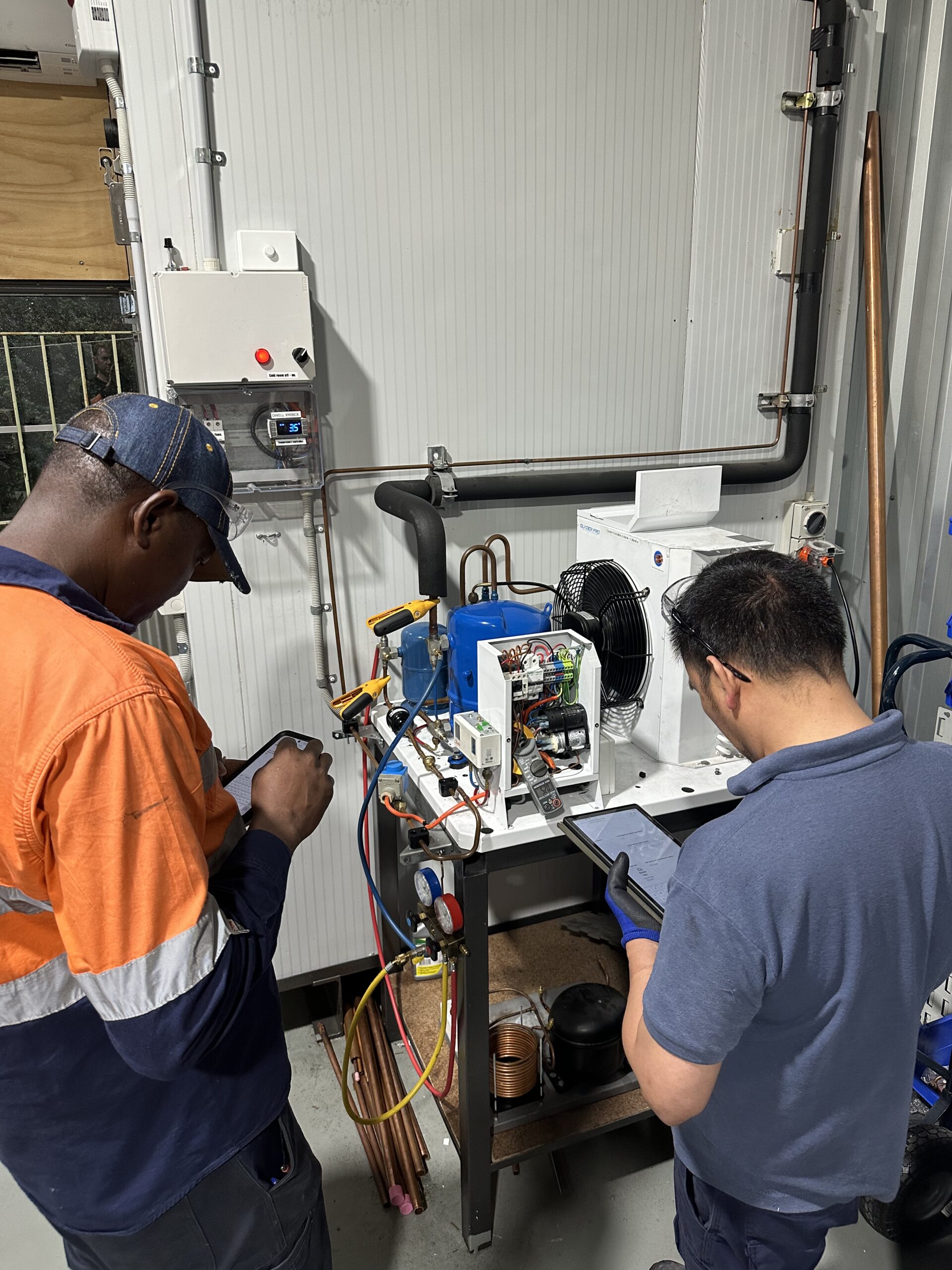 Two men doing electrical work as part of the Cert lll training course
