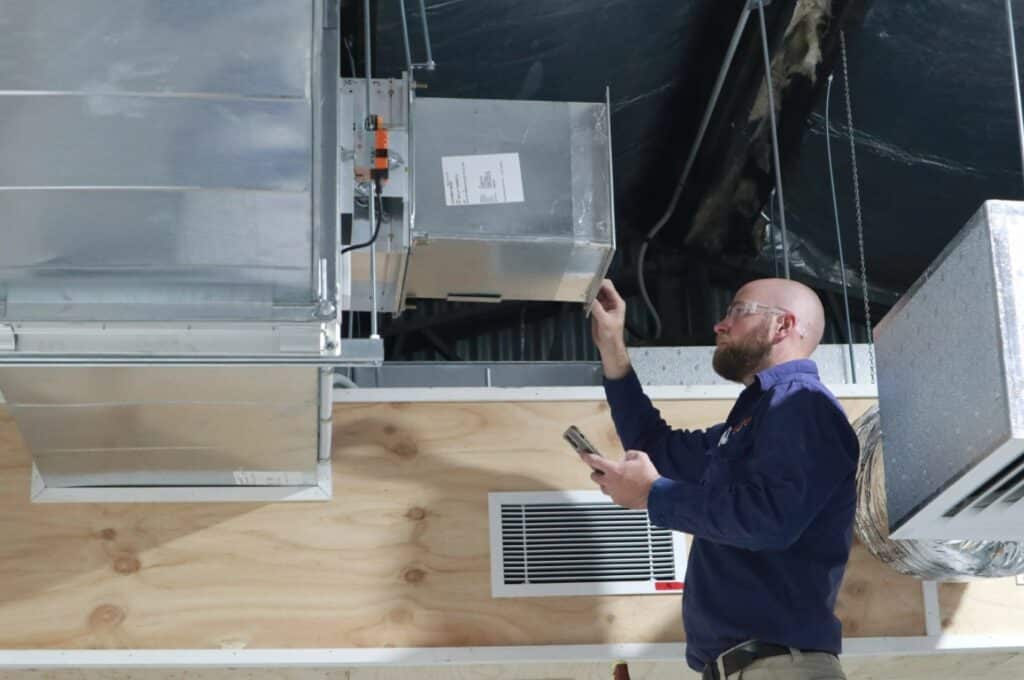 Man working on air conditioning duct.