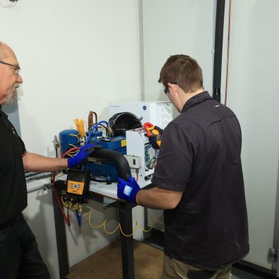 Student and teacher measuring current on air conditioning unit | Featured image for Refrigeration vent with solenoid unit circled | Featured image for Certificate III in Refrigeration and Air Conditioning by Get Skilled Training by Get Skilled Training.