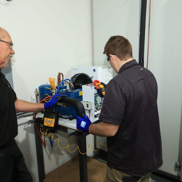 Student and teacher measuring current on air conditioning unit | Featured image for Refrigeration vent with solenoid unit circled | Featured image for Certificate III in Refrigeration and Air Conditioning by Get Skilled Training by Get Skilled Training.
