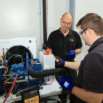 Two men working on refrigeration unit | Featured image for Certificate III in Refrigeration & Air Conditioning on Get Skilled Training