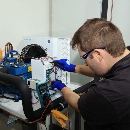 Man working on refrigeration unit | Featured image for Certificate III in Refrigeration & Air Conditioning on Get Skilled Training