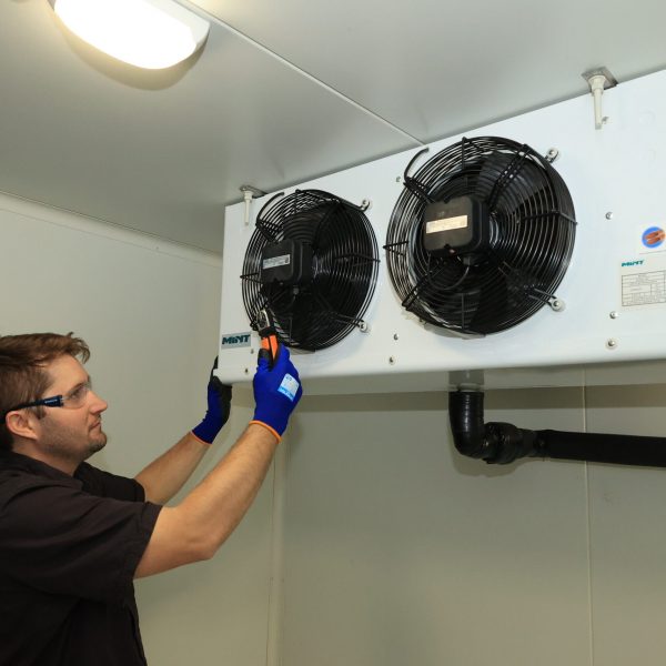 Man measuring refrigeration unit air flow | Featured image for Certificate III in Refrigeration & Air Conditioning on Get Skilled Training