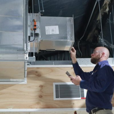 Man working on air conditioning duct.