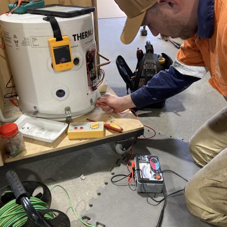 Technician testing electronics of gas appliance | Featured image for Gas Appliances/Equipment Limited to 250Vac – Restricted Electrical Licence Course by Get Skilled Training.