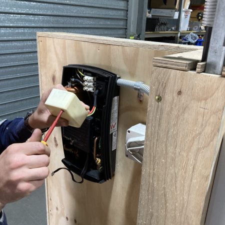 Man working on electrical socket | Featured image for Electronic Equipment – Restricted Electrical Licence Course by Get Skilled Training.