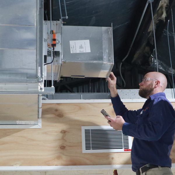 Man working on air conditioning duct.