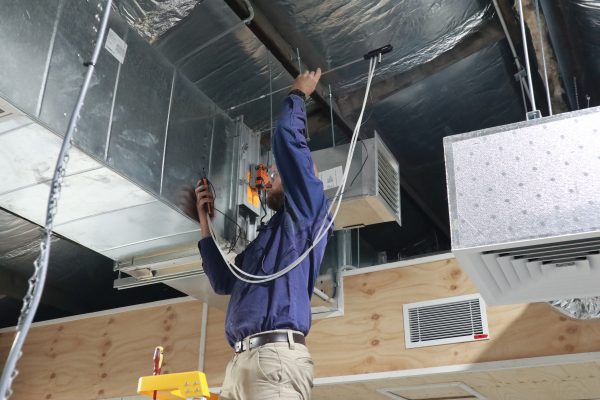 Man working on air vents.